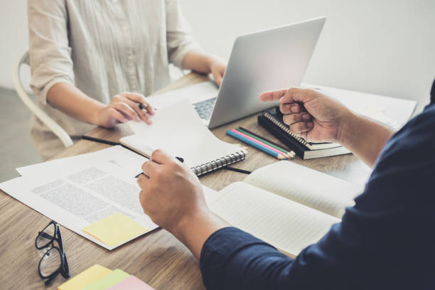 istock Young students campus or classmates with helps friend studying for a test an exam in workbook learning in classroom, Tutor books with friends, Education school concept 946924716