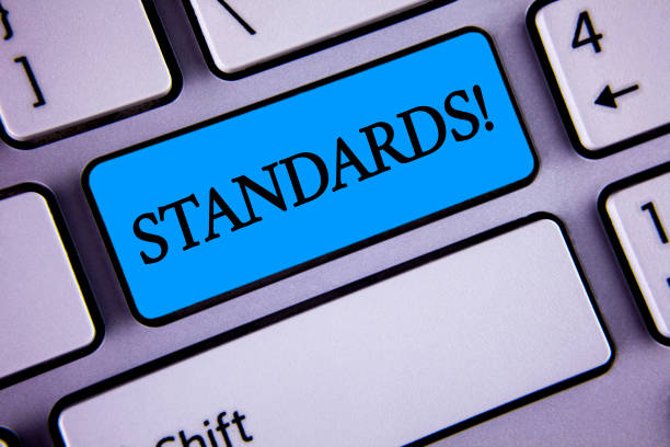 istock Writing note showing  Standards Motivational Call. Business photo showcasing Quality Controls Regulations Guidelines written on Blue Key Button on White Keyboard with copy space. Top view. 946934832