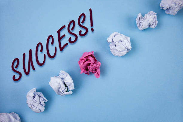 istock Handwriting text writing Success Motivational Call. Concept meaning Achievement Accomplishment of some purpose written on Plain Blue background Crumpled Paper Balls next to it. 946935036