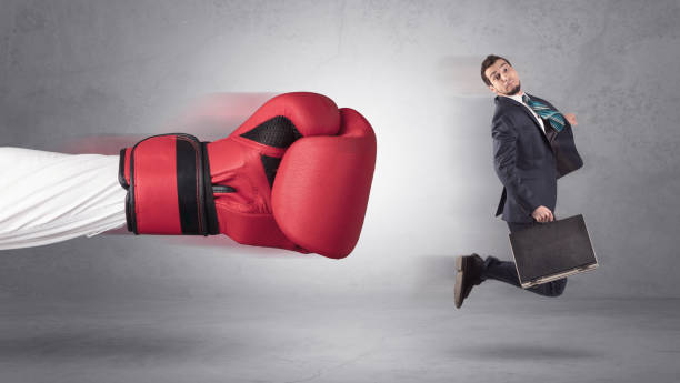 istock Businessman gets a hit from a giant hand 946937940