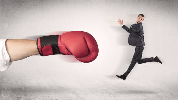 istock Businessman gets fired by a huge boxing hand 946937976