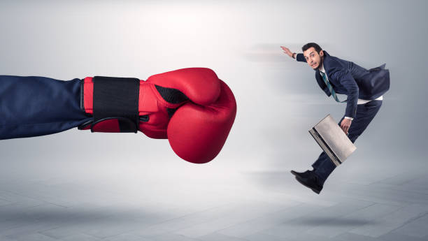 istock Giant hand gives a kick to a small businessman 946938020