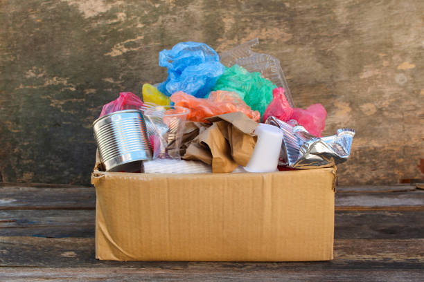 istock Box with trash on wooden background 946938854