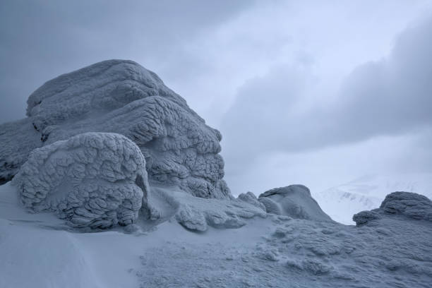 istock At the high mountains there are fantastic, interesting, frozen structured rocks looking like mystical fairytale figures. The panoramic view with the fog, high peaks in snow, adventure mood in the winter day. 946949268