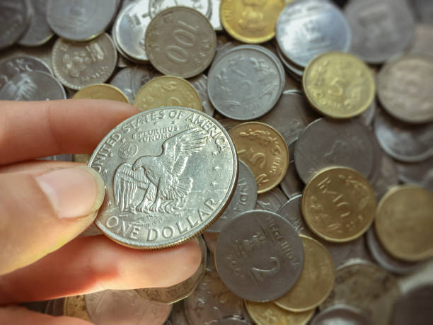 istock Close-up of hands holding one dollar coin. 946950062