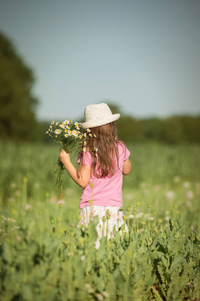 istock Girl with flowers from behind 946952772