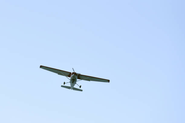 istock The light airplane flies low overhead on a blue sky background 946956360