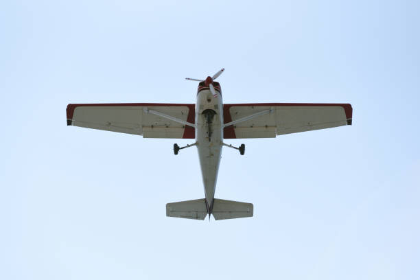 istock The light airplane flies low overhead on a blue sky background 946956528