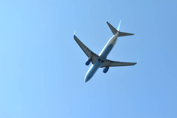 istock The passenger plane flies low overhead on a blue sky background. 946956908