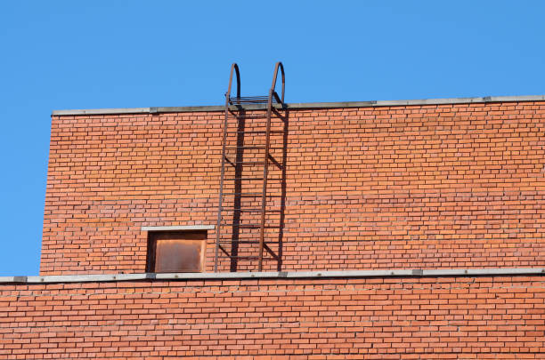 Brick wall of the house roofs.An iron staircase leads to the roof.