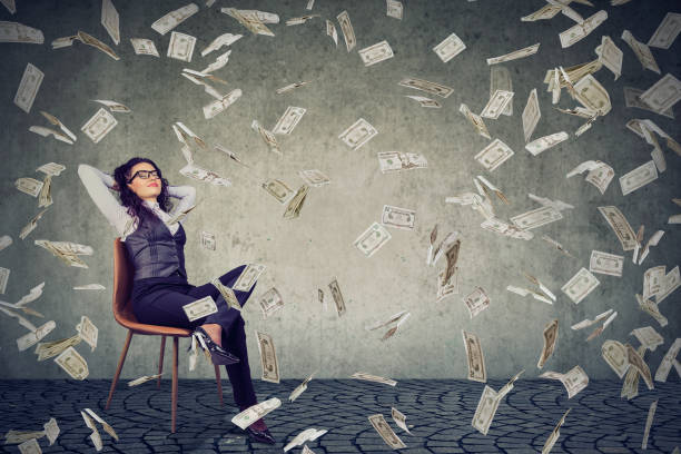 istock Successful woman sitting under money rain 946965068