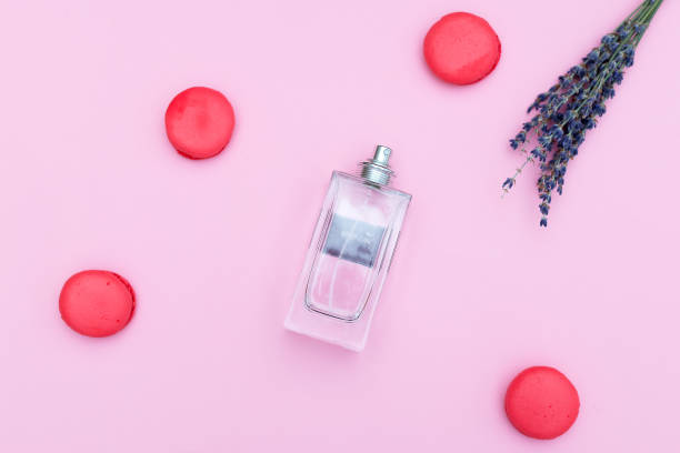 istock Female perfume and strawberry macaroons on a pink background. Flat lay 946968534