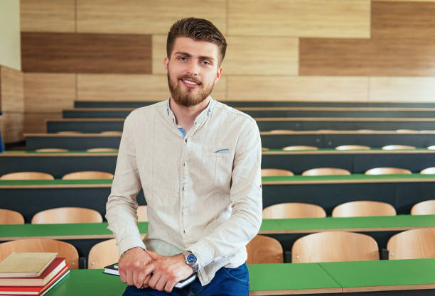istock Portrait of student with books in empty lecture hall 946975338