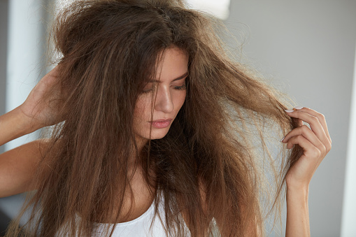 Mujer sosteniendo largas cabello seco dañado. Daño del pelo, cuidado del cabello. photo