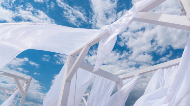 istock Sheds  awning with fabric white curtains on the seashore breeze in the wind 946987088