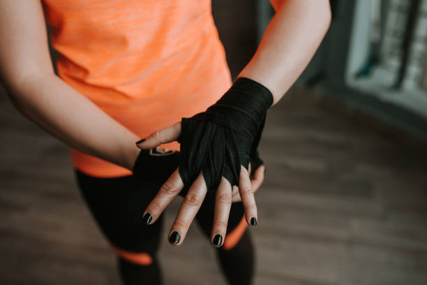 istock Close-up image of female hand with black strap. Preparing for boxing. 946987258