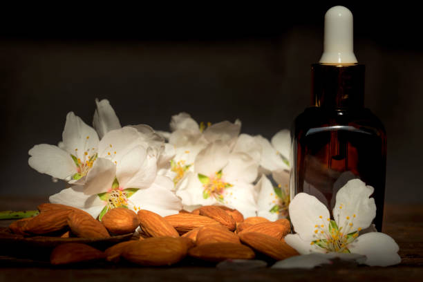 istock Almonds, oil and white flowers on dark background 946987284
