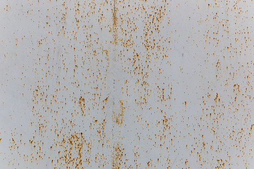 The texture of painted metal gates covered with shallow rust