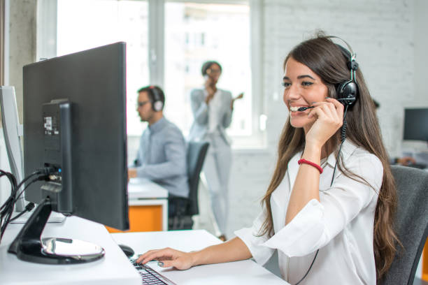 junge freundliche betreiber frau mit headsets, die arbeit in einem call-center agent. - on the phone customer service representative beautiful business person stock-fotos und bilder