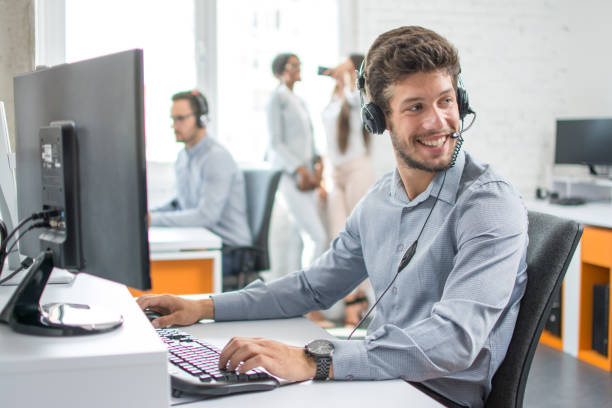 istock Smiling handsome customer support operator agent with hands-free device working in call center 946991482