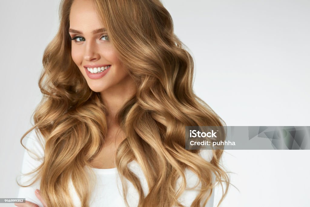 Beautiful Curly Hair. Girl With Wavy Long Hair Portrait. Volume Beautiful Curly Hair. Smiling Girl With Healthy Wavy Long Blonde Hair. Portrait Happy Woman With Beauty Face, Sexy Makeup And Perfect Hair Curls. Volume, Hairstyle, Hairdressing Concept. High Quality Hair Stock Photo