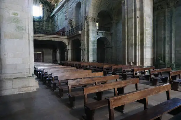 Empty church pews in a Gothic setting.