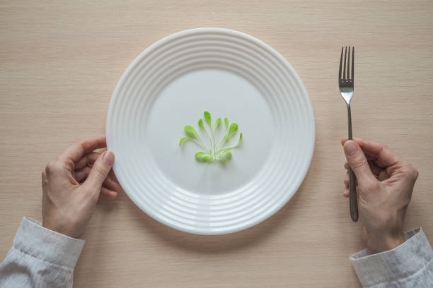 istock Young salad on a plate. Humorous concept of a diet. 947007610