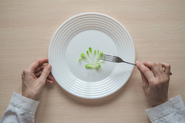 istock Young salad on a plate. Humorous concept of a diet. 947007706