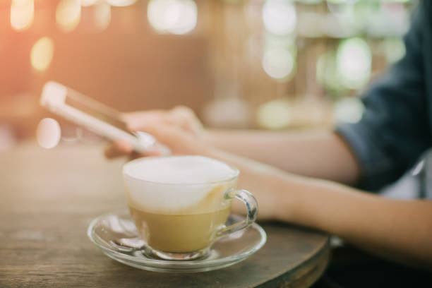 istock Womans hands holding smartphone at coffee shop 947009044