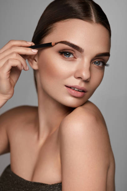 istock Beautiful Sexy Woman Contouring Eyebrows. Glamorous Makeup 947018038