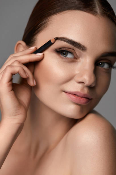 istock Beautiful Sexy Woman Contouring Eyebrows. Glamorous Makeup 947018132