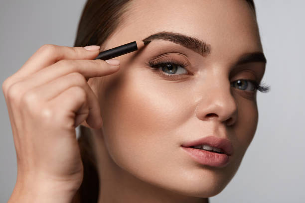 istock Beautiful Woman Contouring Eyebrows With Pencil. Beauty 947018784