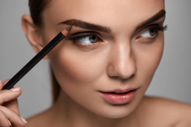 istock Beautiful Woman Contouring Eyebrows With Pencil. Beauty 947018828