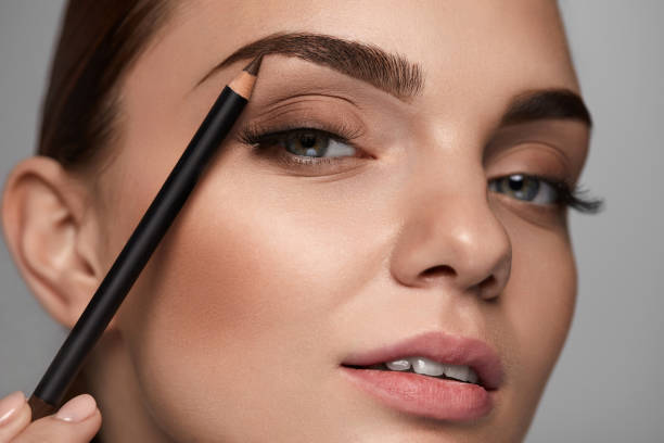 hermosa mujer que contornea las cejas con el lápiz. belleza - makeup pencils fotografías e imágenes de stock