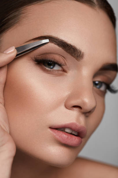 istock Beautiful Woman Plucking Eyebrows. Beauty Brows Correction 947019364
