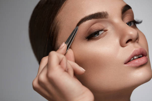 istock Beautiful Woman Plucking Eyebrows. Beauty Brows Correction 947019480