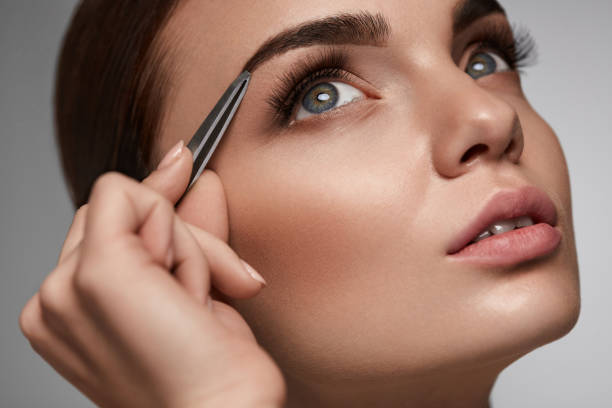 istock Beautiful Woman Plucking Eyebrows. Beauty Brows Correction 947020364