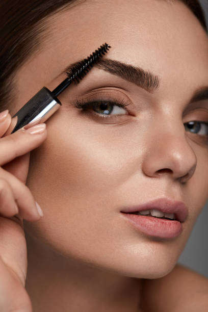 istock Beautiful Woman With Fresh Makeup And Brush For Eyebrows 947021816