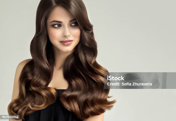 Photo libre de droit de Jeune Brune Aux Cheveux Beau Modèle Avec Des Cheveux Long Bouclé Bien Soigné Vagues De Cheveux Excellent banque d'images et plus d'images libres de droit de Cheveux ou Poils