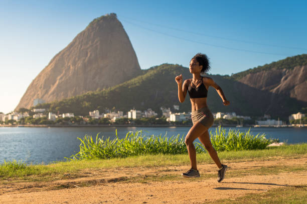 fitness-frau läuft auf einem feldweg - sugarloaf mountain mountain rio de janeiro brazil stock-fotos und bilder