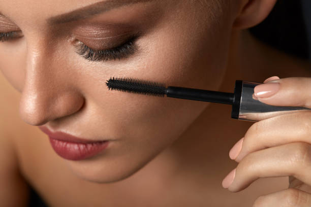 istock Beautiful Woman Using Black Mascara On Closed Eyes 947030522