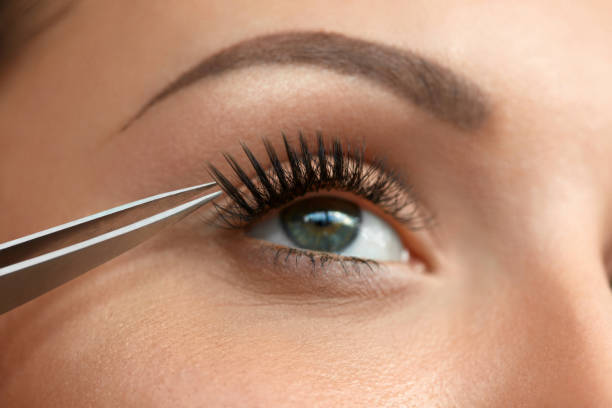 primer plano de bella mujer ojo con pestañas postizas negras largo - applying make up flash fotografías e imágenes de stock