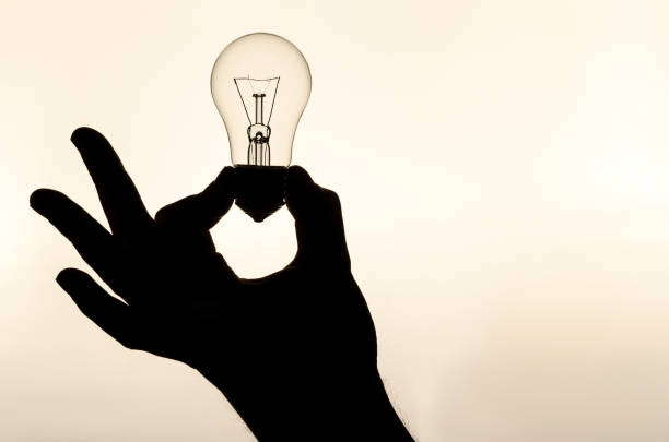 istock incandescent lamp in hand 947042028