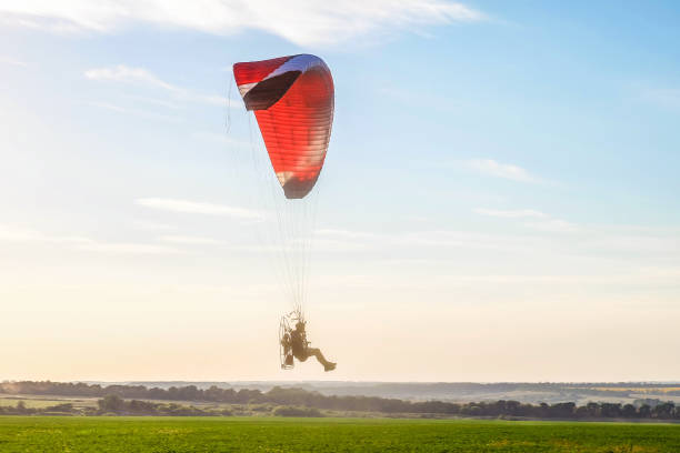 istock Flight on a motor glider in the blue sky with bright backlight sunlight over the green plain. Solar illumination of the pilot. 947045222
