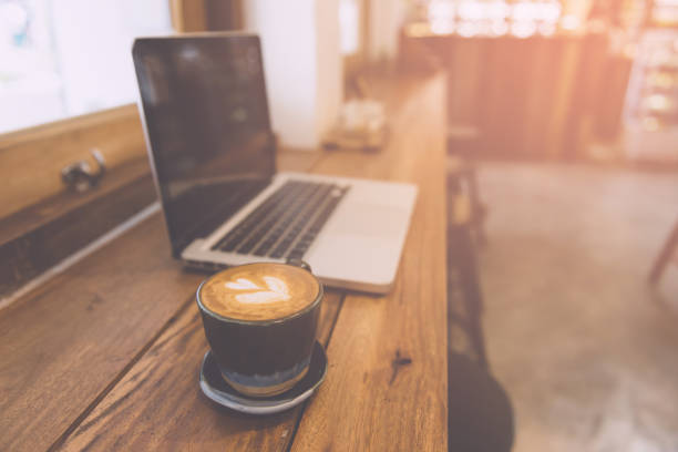 istock Laptop and coffee cup on wooden table 947046074