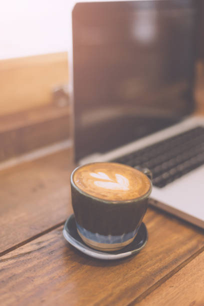 istock Laptop and coffee cup on wooden table 947048082