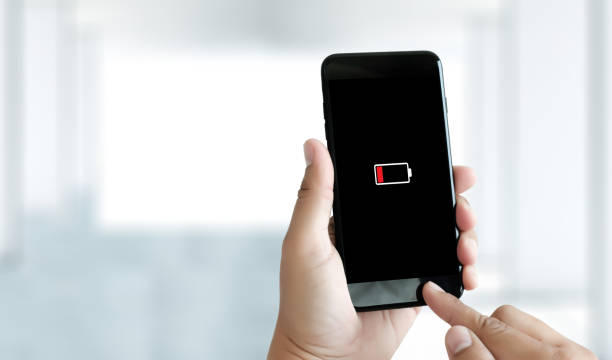 istock Close up man hands using smart phone battery low charged battery screen 947048150