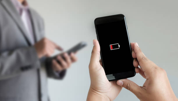 istock Close up man hands using smart phone battery low charged battery screen 947048226