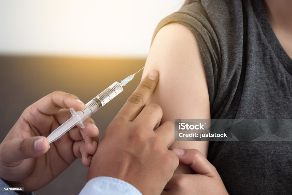 Medicine and health care concept Doctor giving patient vaccine insulin or vaccination Human Papilloma Virus Stock Photo