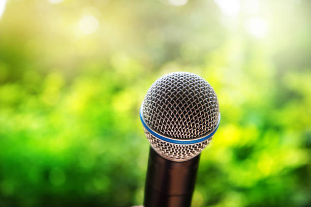 istock microphone for communication presentation or singing with green summer nature background 947051640